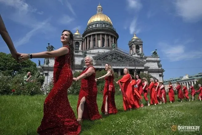 Женщины выстроились в форме сердца в красных платьях. Инициатива родилась в Красноярске, участие платное; акция прошла в нескольких городах.